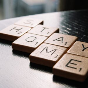 letter tiles arranged in text stay home on table