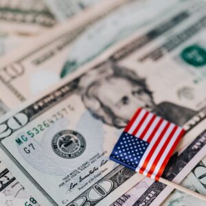 stack of usa money and national flag