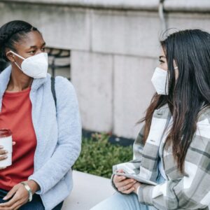 young multiracial ladies chatting on bench in park after studies