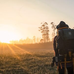 man in black backpack during golden hour