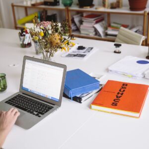 photo of orange book beside laptop