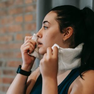 ethnic woman with towel exercising in gym