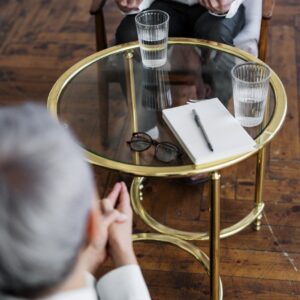 woman in black long sleeve shirt sitting on brown wooden chair