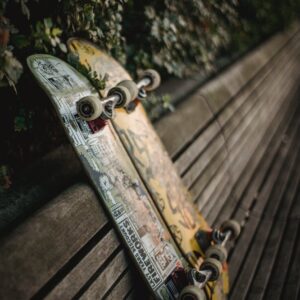 skateboards placed on wooden bench in green park