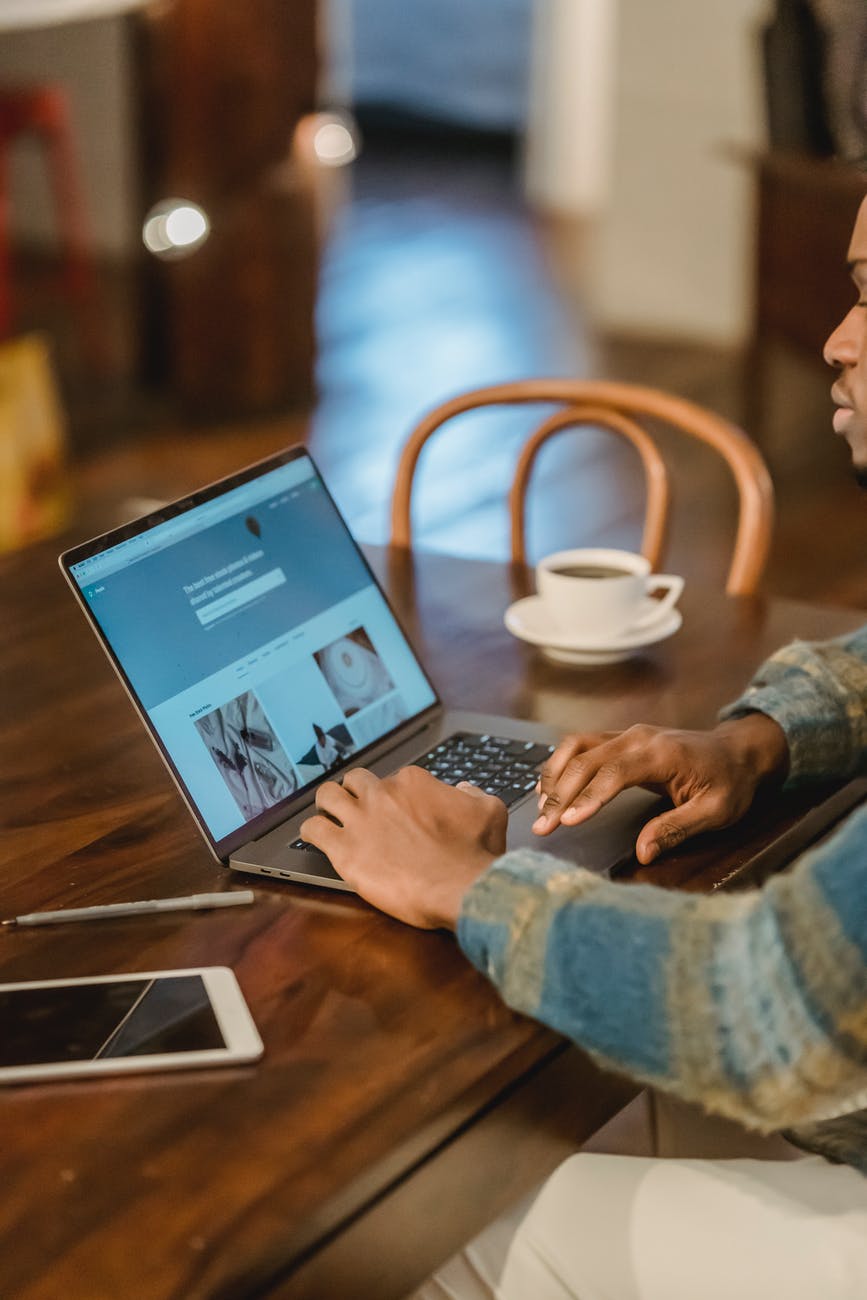 crop man working on laptop in kitchen