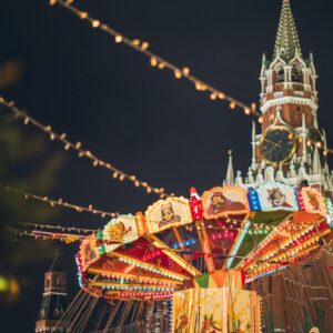 colorful luminous carousel against kremlin on red square at night