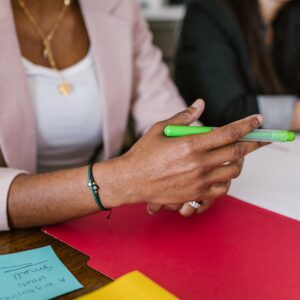 woman in white shirt holding green pen