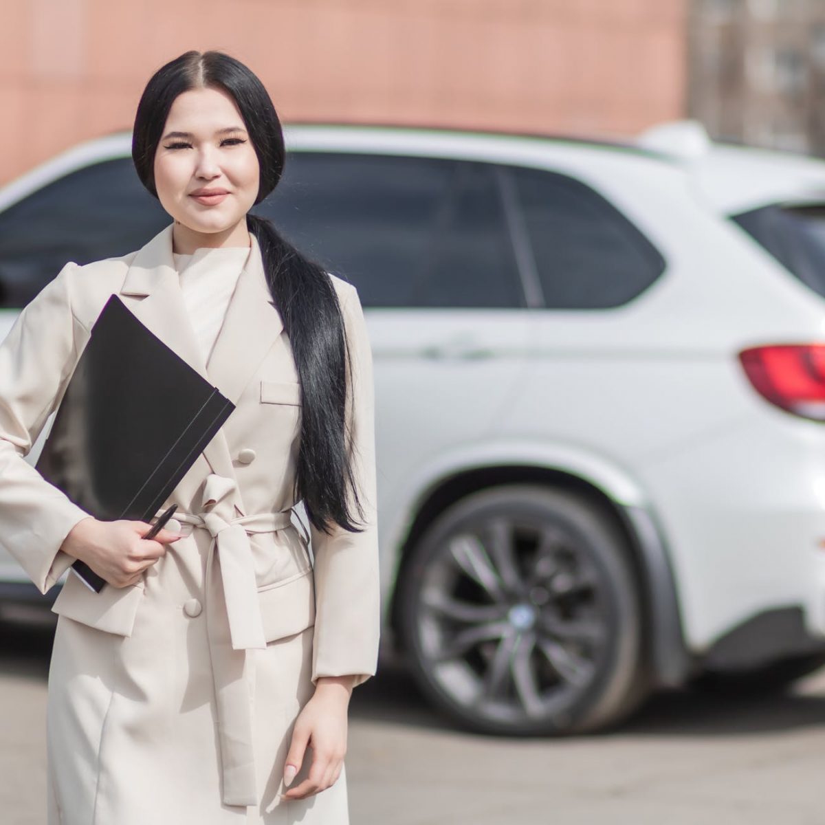 woman in beige corporate clothes holding black folder