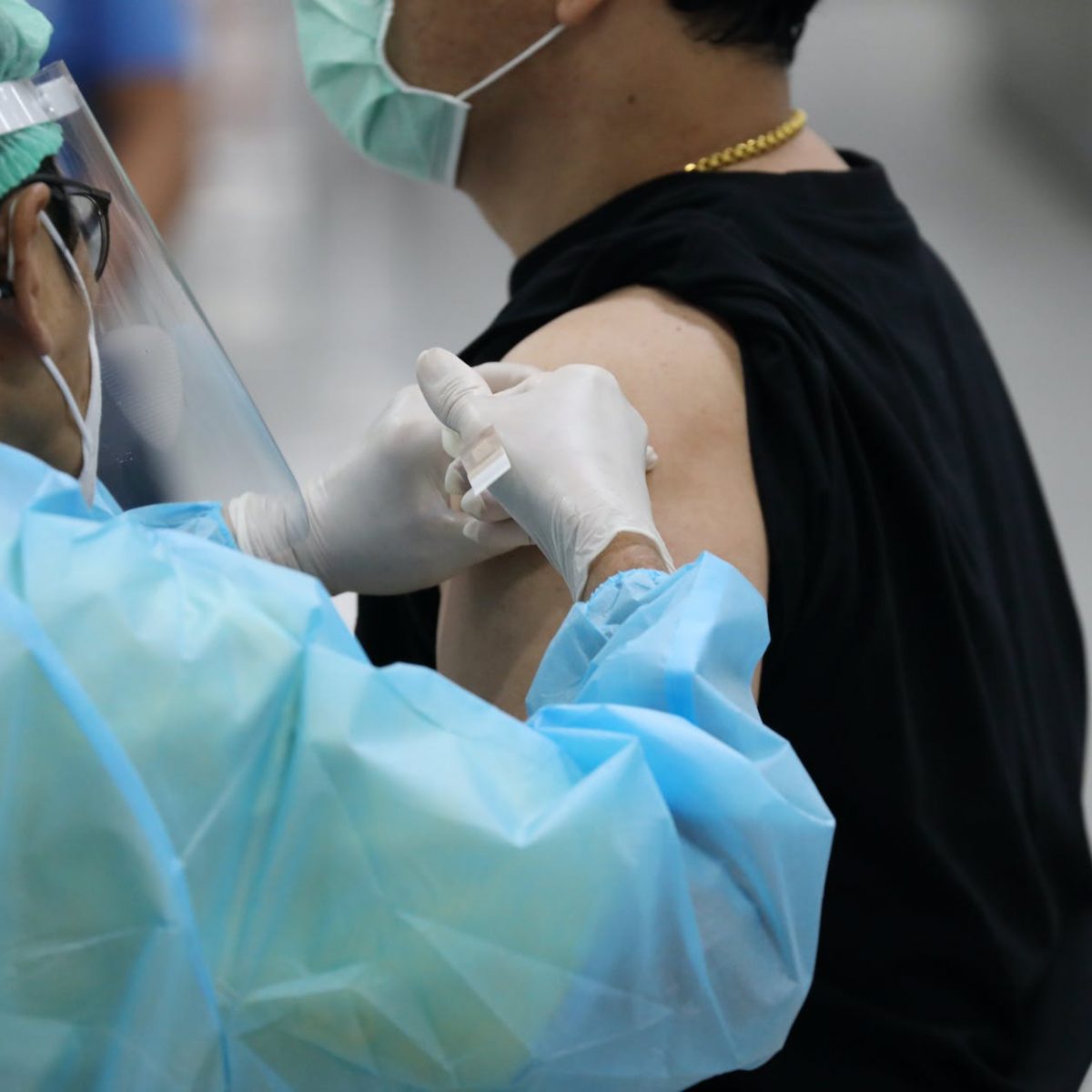 man in black shirt getting vaccinated