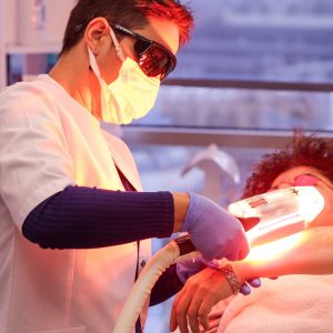 woman giving laser treatment