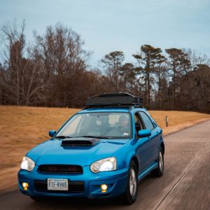 a person driving a blue car