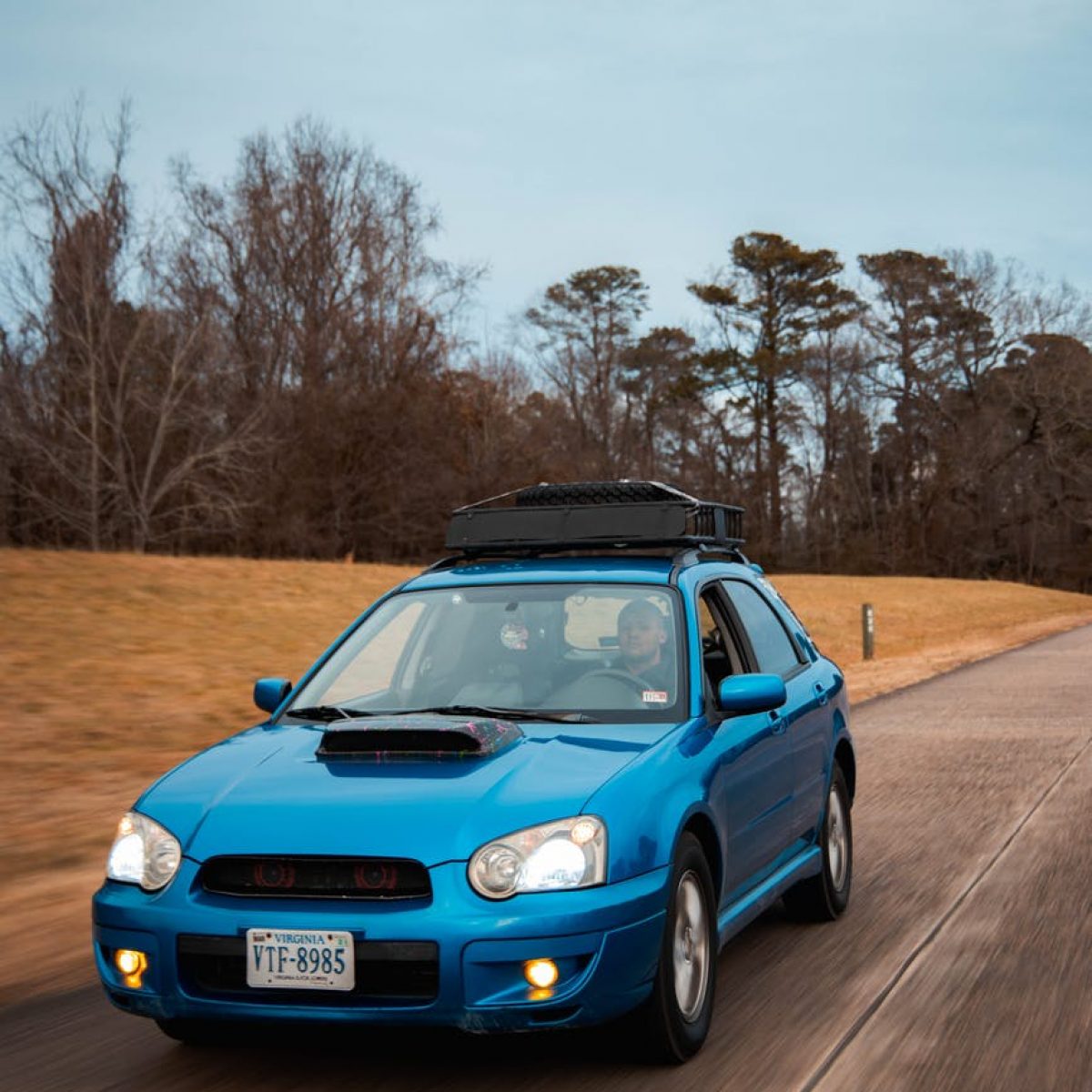 a person driving a blue car