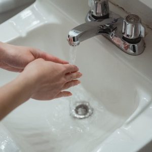 person washing hands on washbasin
