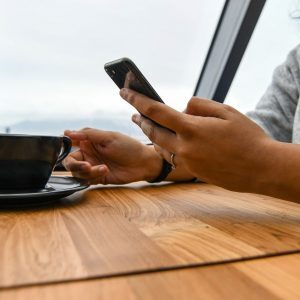 person holding ceramic cup on table