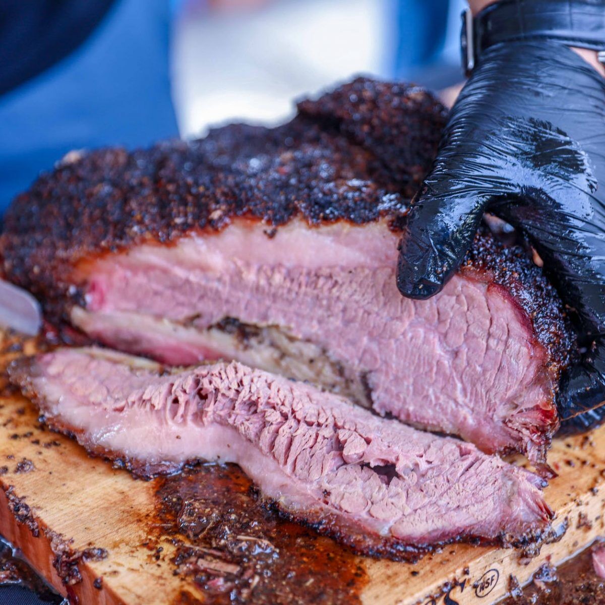 a person slicing barbecue beef brisket