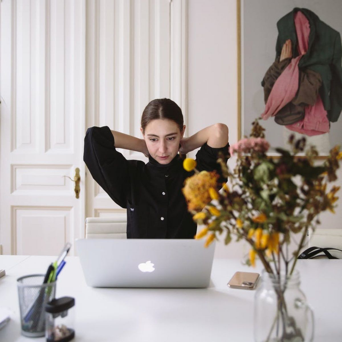 woman in black blouse sitting in front of silver laptop