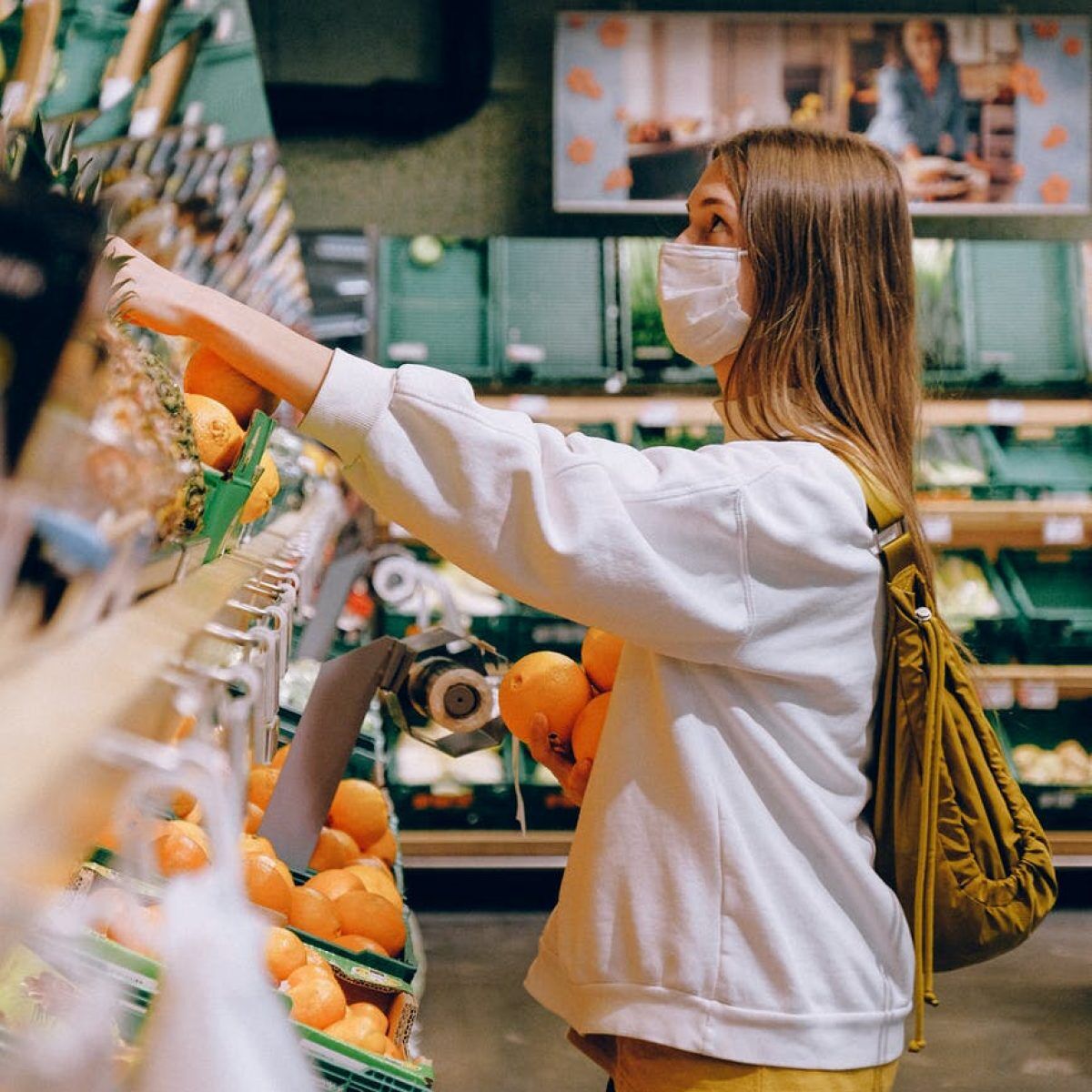 woman in white long sleeve jacket shopping for fruits
