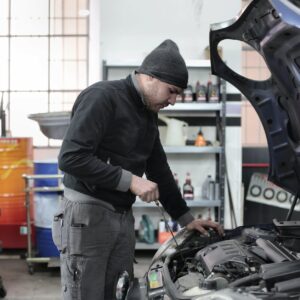 photo of man inspecting car engine