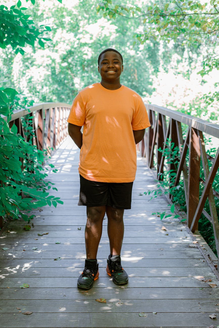 a boy standing on footbridge