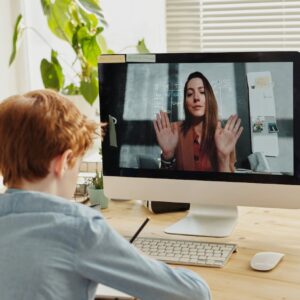 photo of boy video calling with a woman through imac