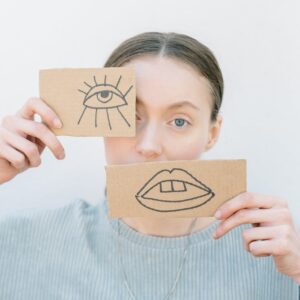woman holding cardboard pieces with drawings
