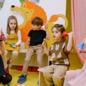 children with her students holding different color bells