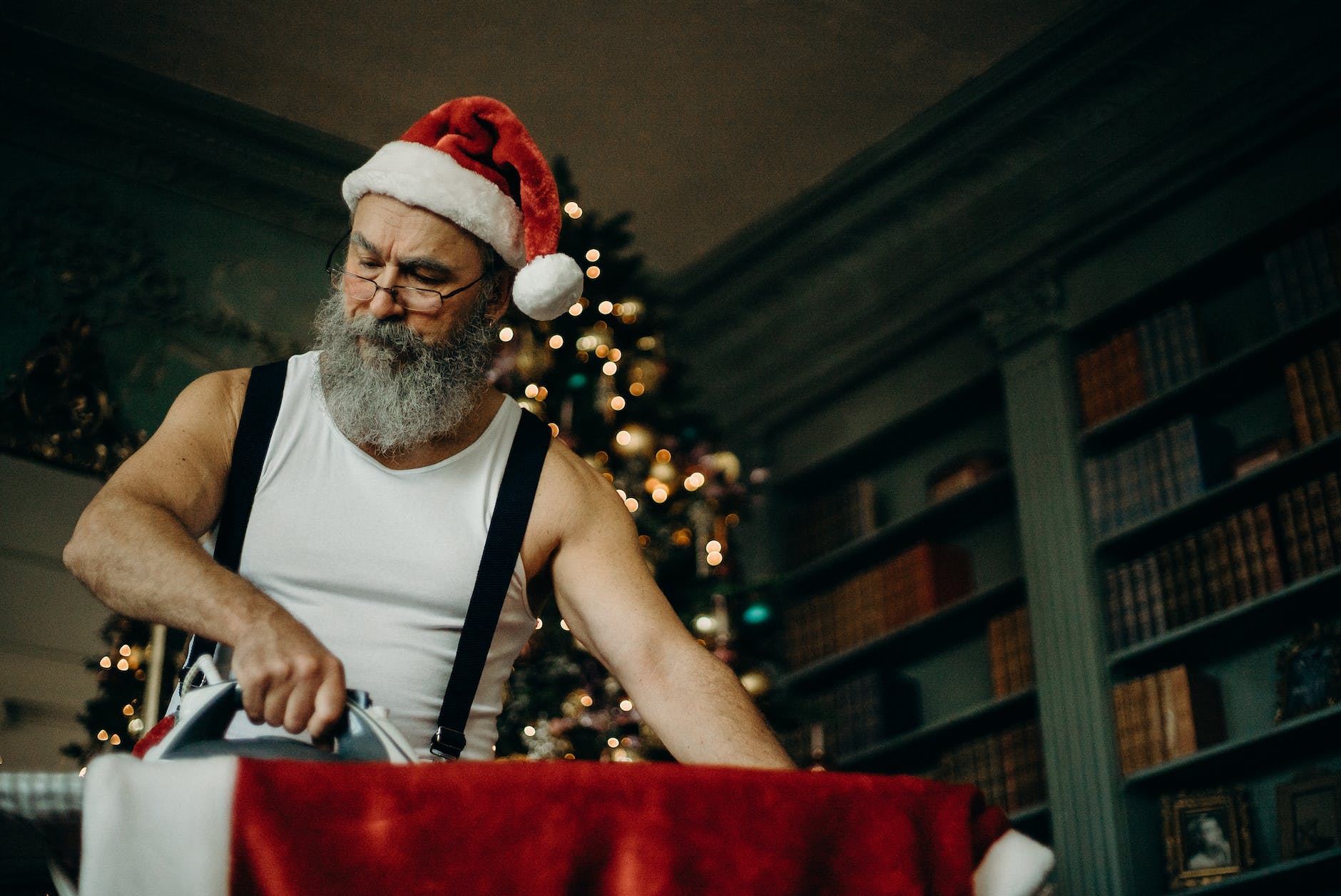 man in white tank top ironing red top