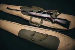 black rifle with scope and brown gig bag