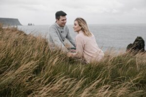 cheerful couple holding hands while spending time on seashore