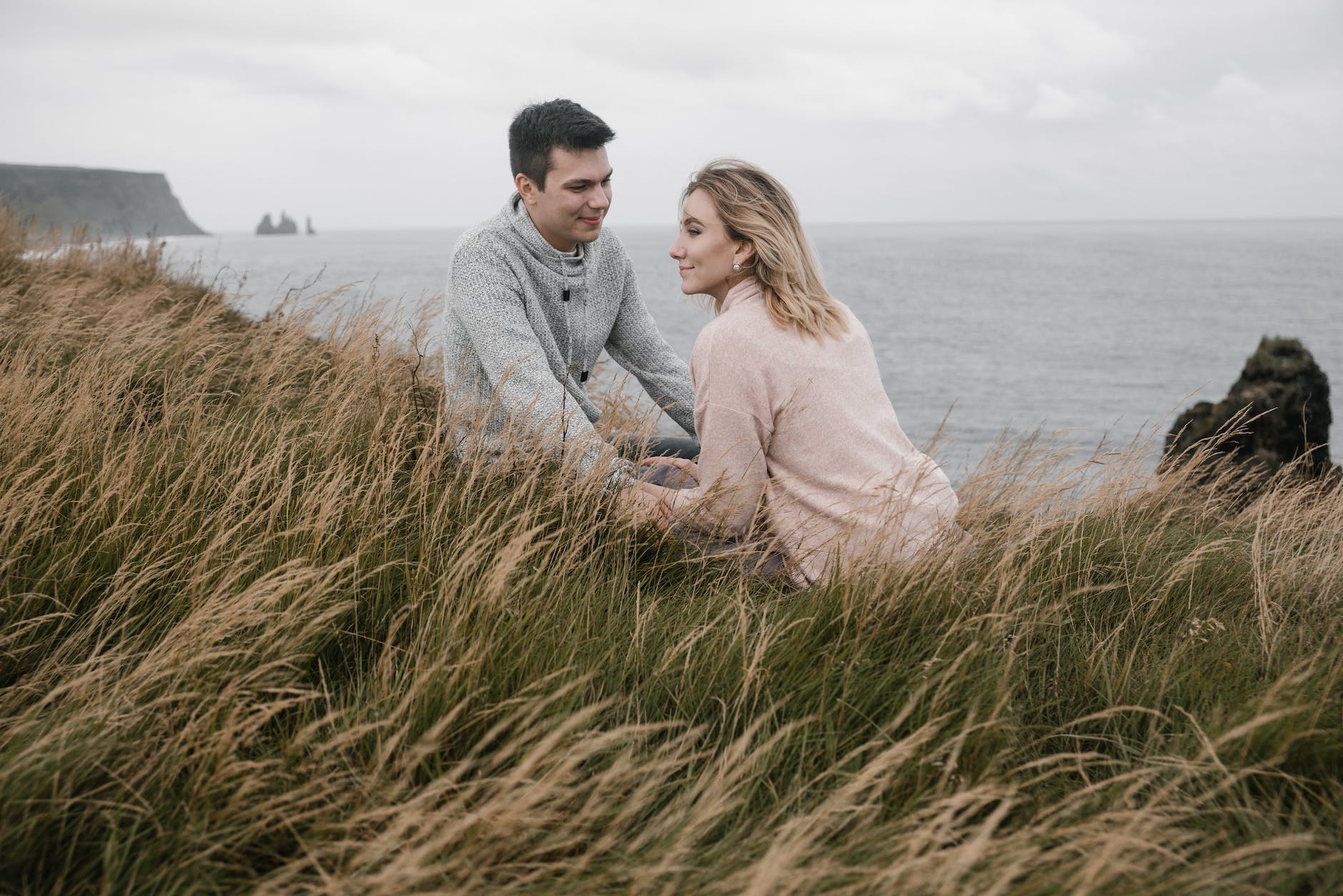 cheerful couple holding hands while spending time on seashore