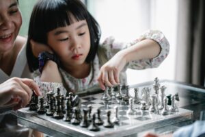 pensive asian girl playing chess