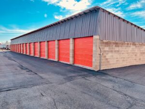 a storage building with red doors and a sky background