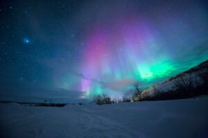 northern lights over snow-capped mountian
