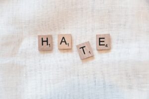 the word hate spelled with scrabbled wood blocks