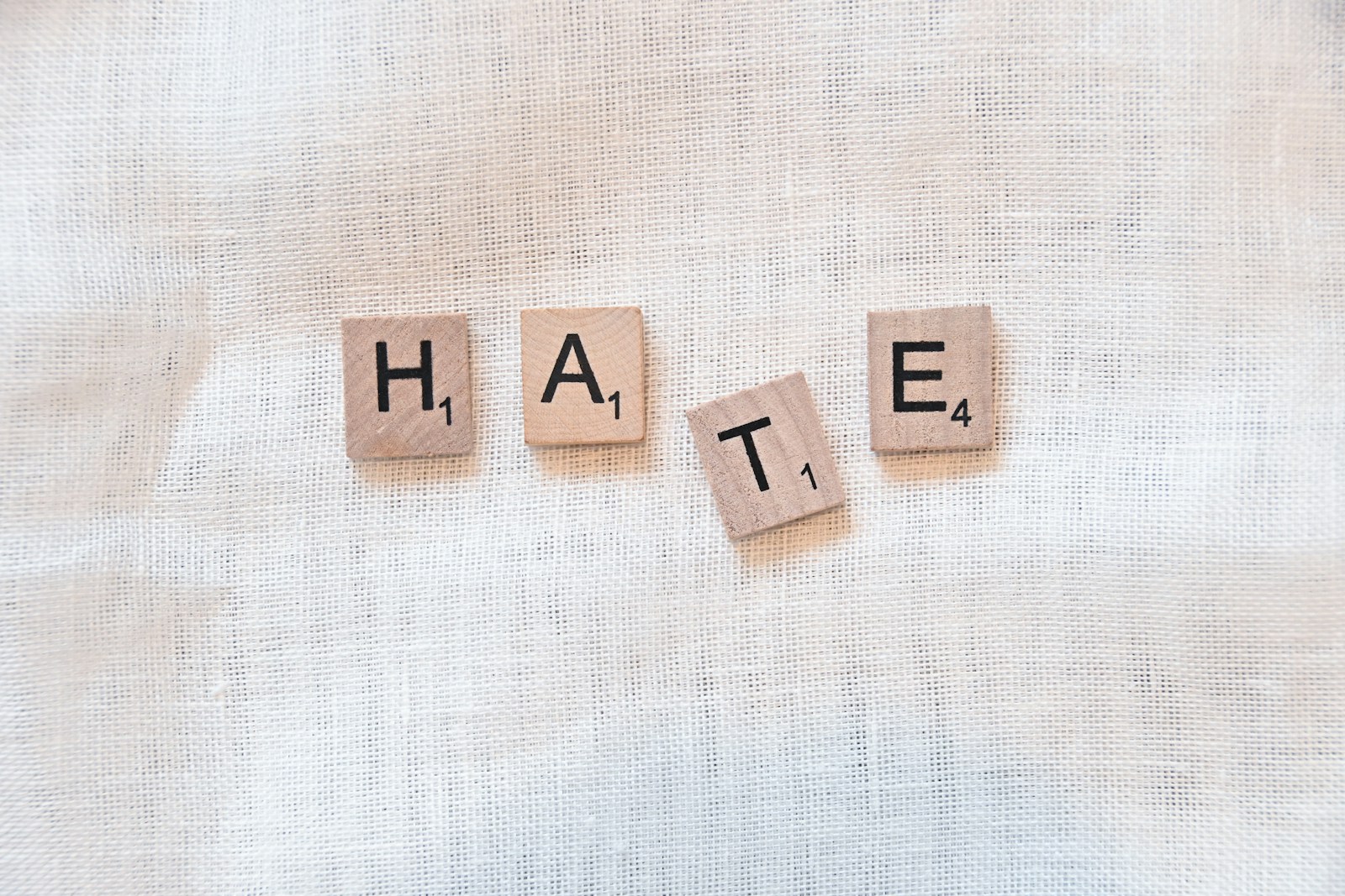the word hate spelled with scrabbled wood blocks