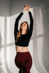 a woman in a black top and maroon pants