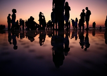 silhouette of people standing on mirror during golden hour