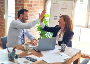 man in white dress shirt sitting beside woman in black long sleeve shirt