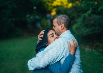 man hugging woman near trees
