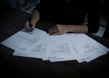 a woman sitting at a table with lots of papers