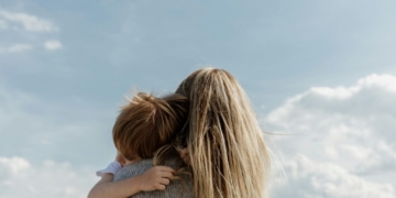 woman in gray shirt covering her face with her hair
