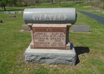 a headstone in the middle of a cemetery