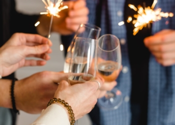 woman in white long sleeve shirt holding clear wine glass